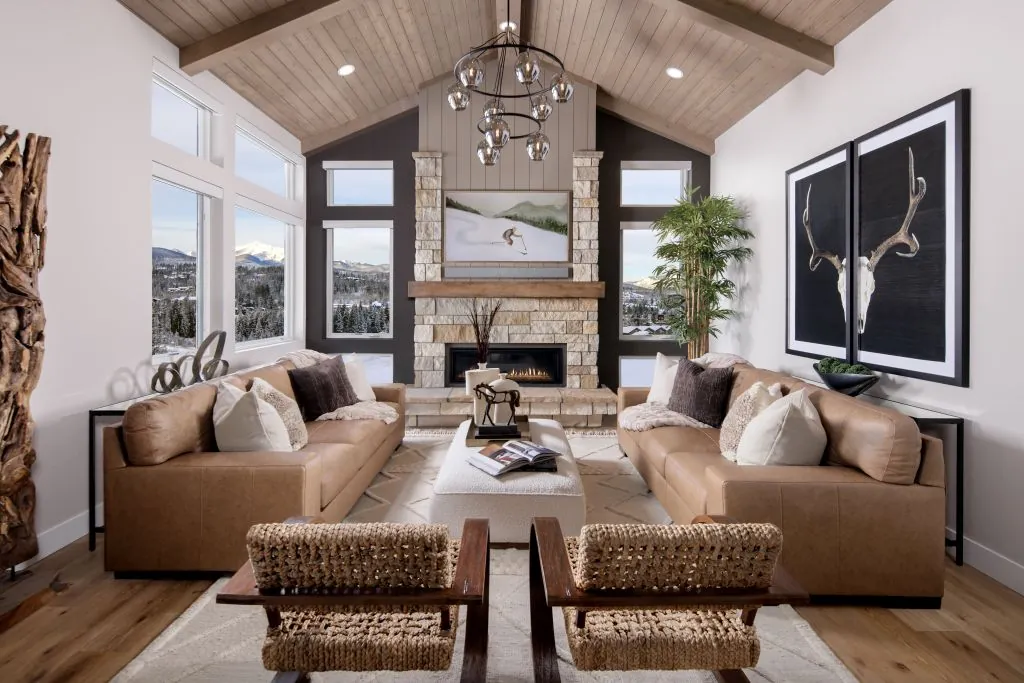 Rendezvous home furnished living room with natural stone fireplace and modern earth tone palettes 