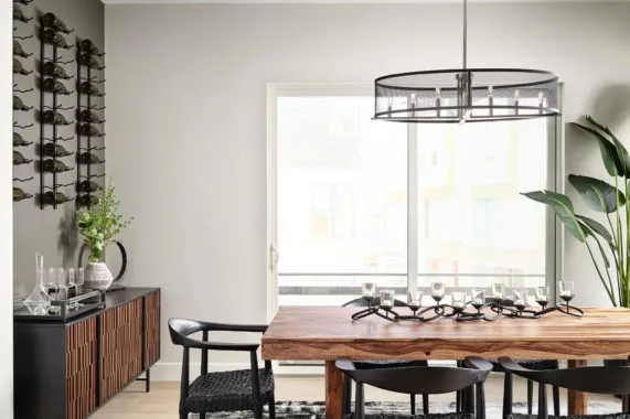 Dining room with wooden table, black chairs, and modern decor