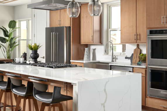 Kitchen, white countertop island with barstools and overhead fan